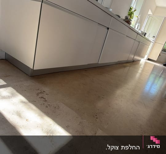 מטבח עם ארונות לבנים ורצפת אבן